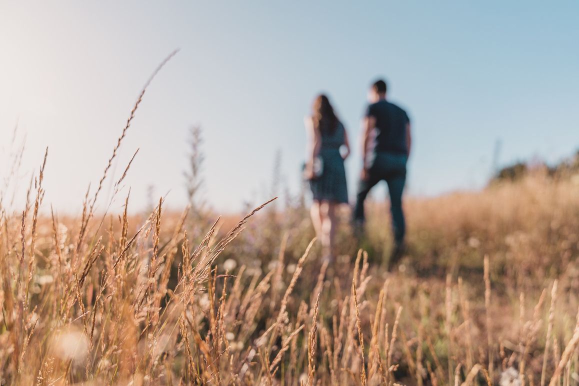 A Couple Walking on the Field of Grass